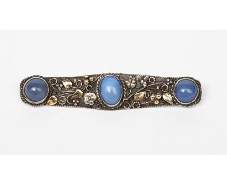 A silver and moonstone bar brooch in the manner of the Artificers Guild, the shaped rectangular panel with applied flowers an