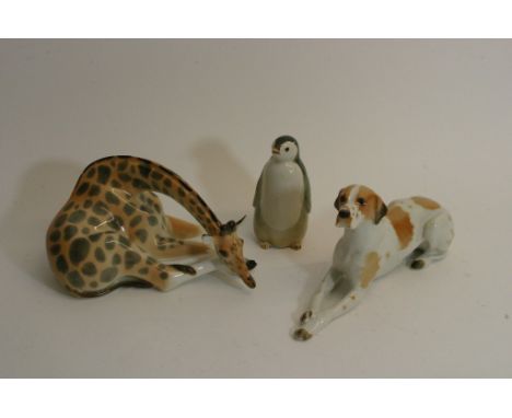 Three Russian ceramic figures comprising a Lomonosov giraffe and a penguin plus a dog (possibly Lomonosov).