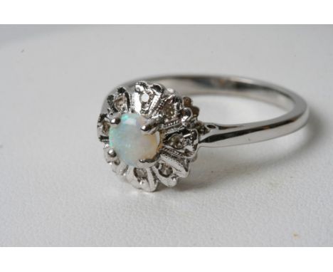 A 9ct white gold ring inset with an opal with chip stone diamonds 