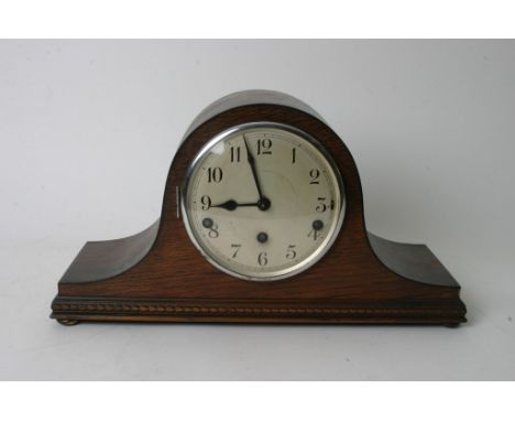 An oak cased helmet shaped mantel clock.