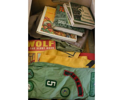 A collection of scouting items including books, clothing and a sash with badges applied 
