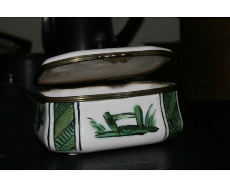 A late 19th century enamel box in colours of green and white depicting a naive image of an oriental fisherman on a river bank