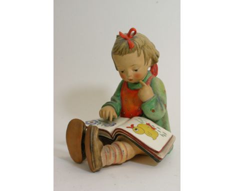 A large Goebel figure of a girl reading a picture book. Base stamped 1972.
