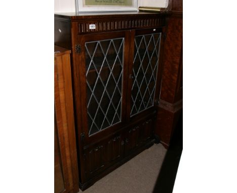 An oak bookcase with a pair of lead light glazed doors 