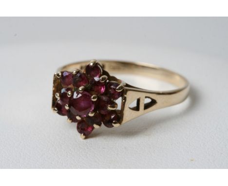 A 9ct gold garnet ring in the form of a flower head 