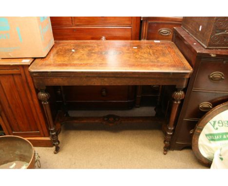 A Victorian walnut veneer inlaid card table on casters
