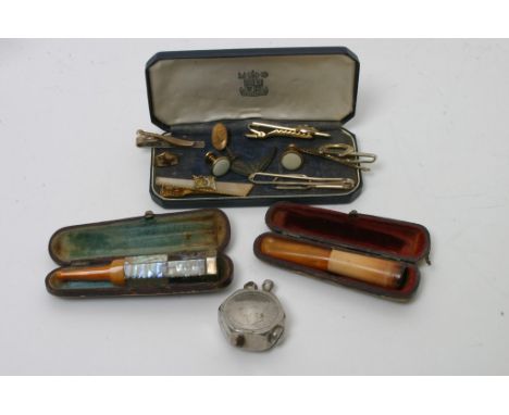 Two cased cheroot holders, one of of mother of pearl, an interesting lighter depicting George VI and some cufflinks