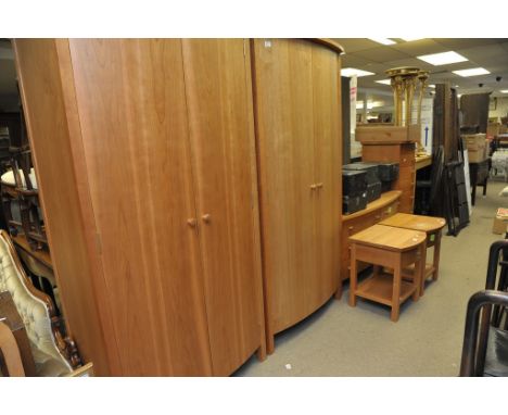 A quality modern cherry wood bedroom suite comprising a pair of bow fronted wardrobes , a flight of seven drawers ,Bedside ca