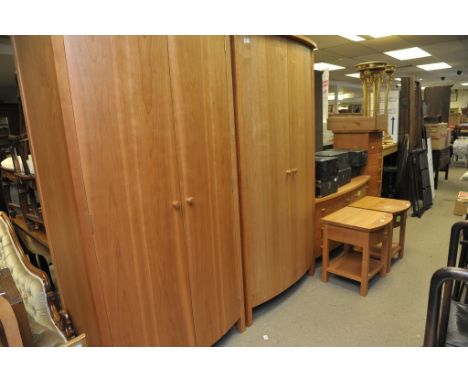 A quality modern cherry wood bedroom suite comprising a pair of bow fronted wardrobes , a flight of seven drawers ,Bedside ca