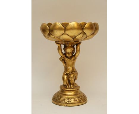 An antique, gilt ceramic centrepiece figure of a putto, his arms held aloft supporting a patterned bowl