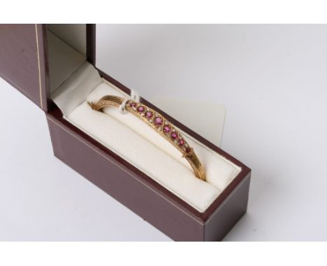 A quality 9ct gold bangle set with graduating Ruby's and diamonds