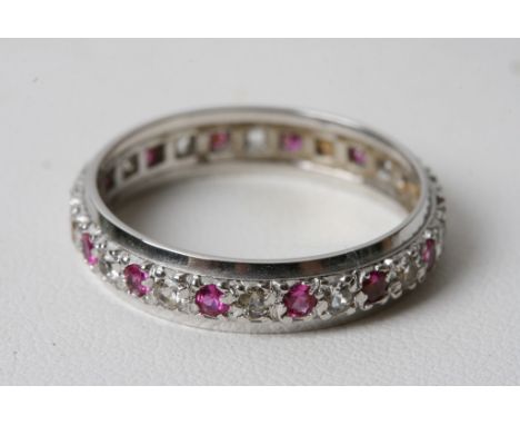 A 9ct white gold eternity ring inset with alternating ruby and diamond stones 