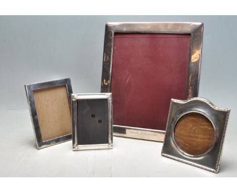 A group of four silver / silver plated fronted photo frames to include an edwardian engine turned example with a round frame 