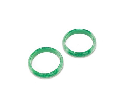 A PAIR OF JADEITE BANGLES19th centuryEach translucent bangle of bright green colour with pale cloudy inclusions, rounded to t