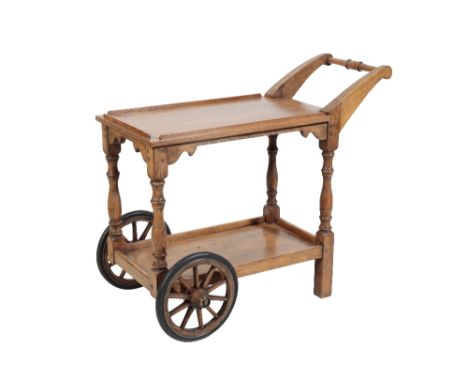 * NIGEL GRIFFITHS: A HANDMADE OAK SERVING TROLLEY of Jacobean style, with turnd and shaped handle and front wheels, 95cm high