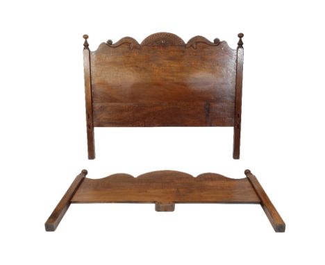 * NIGEL GRIFFITHS: A HANDMADE OAK SUPERKING SIZE BED of Jacobean style, the headboard with a shaped and carved toprail with f