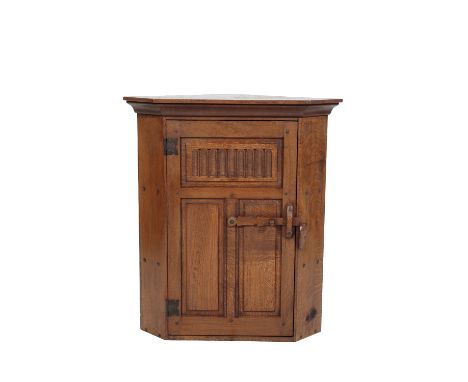 * NIGEL GRIFFITHS: A HANDMADE OAK HANGING CORNER CUPBOARD of Jacobean style, the single door with carved panel decoration and