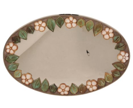   STAINLESS STEEL FRAMED MIRROR oval form, the border applied with a freize of ceramic tiles in the form of leaves and flower