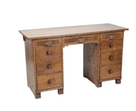 * NIGEL GRIFFITHS: A HANDMADE OAK DESK of Jacobean style, the rectangular top with a frieze of three drawers with hand carved