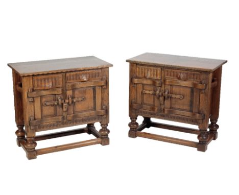 * NIGEL GRIFFITHS: A PAIR OF HANDMADE OAK BEDSIDE CUPBOARDS of Jacobean style, the rectangular tops above twin hand carved dr