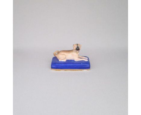 An English porcelain model of a Pug dog laying on a blue rectangular base with soldid gilt lineDate: Circa 1830    Size: 9cm 