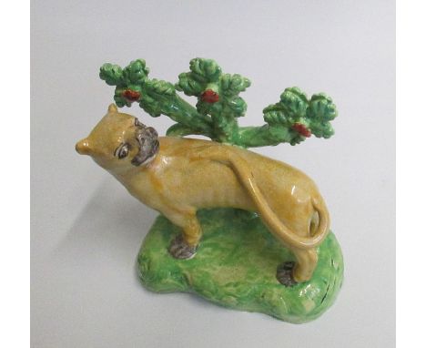 A Staffordshire model of a Lioness standing before bocage Date: circa 1820      Size: 17.5cm high, 14.5cm diameterCondition: 