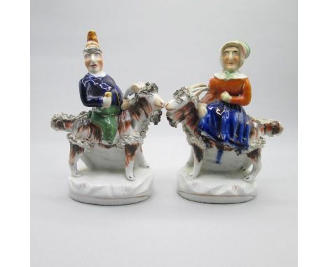A pair of Staffordshire portrait figures of Mr and Mrs Punch both seated on the backs of goats.  Date: Circa 1860       Size: