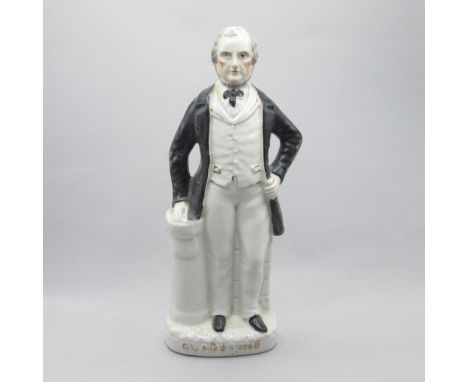 A Staffordshire portrait figure of Gladstone, standing with his right hand on a pedestal and his left hand holding his coat.D