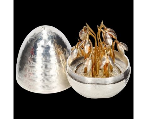 An Elizabeth II silver surprise egg, Peter Nicholas, London 1990, engine turned wave decoration opening to reveal rotatable c