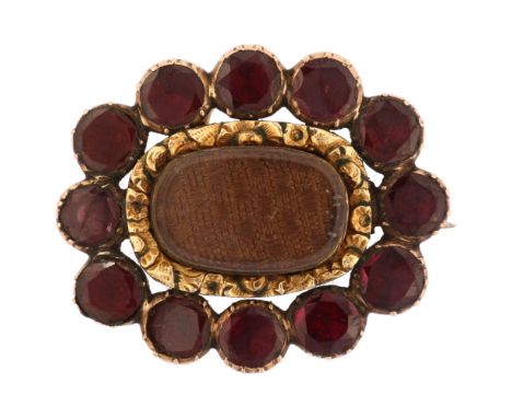 A Georgian gold garnet and hairwork mourning brooch/pendant, circa 1810, unmarked rose gold closed-back settings with central