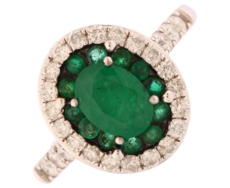 A modern 18th white gold emerald and diamond oval cluster ring, set with oval and round-cut emeralds with modern round brilli