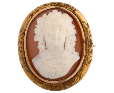 A Victorian shell cameo brooch, relief carved depicting female bust with unmarked yellow metal floral engraved frame, 40.4mm,