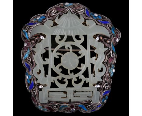 A Chinese carved and pierced jade brooch in silver filigree and enamel shaped setting, 50 x 45mm, 19gSeveral tiny pieces of e