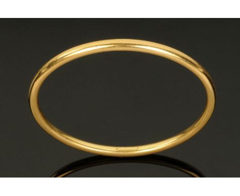 An 18 ct gold hollow bangle, stamped "750".  9.5 grams. 