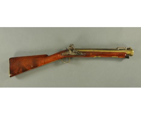 An early 19th century brass barrelled flintlock blunderbuss by H. Nock, with sprung loaded bayonet, ramrod and brass mounts m
