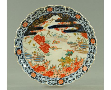 A large Japanese Imari scalloped charger, circa 1870/80, decorated with a mustard yellow Kirin beneath panels of geese agains