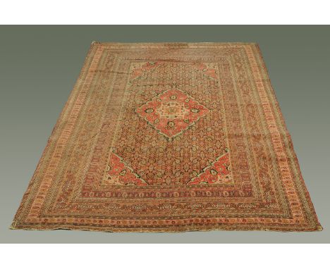 A large Eastern carpet, with centre diamond medallion within rectangular frame, with multiple line border in a variety of col