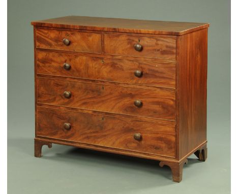 A 19th century mahogany chest of drawers, with two short and three long drawers with wooden knob handles and cockbeading to e