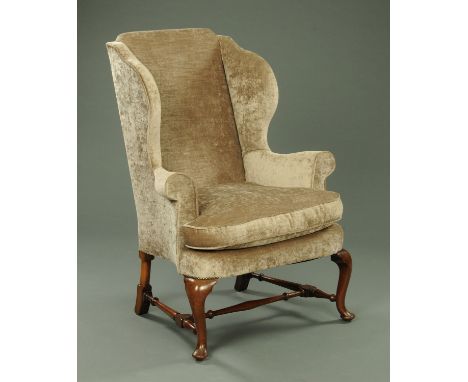 A Queen Anne style wing easy chair, upholstered in mushroom velvet type material and raised on front cabriole legs with turne