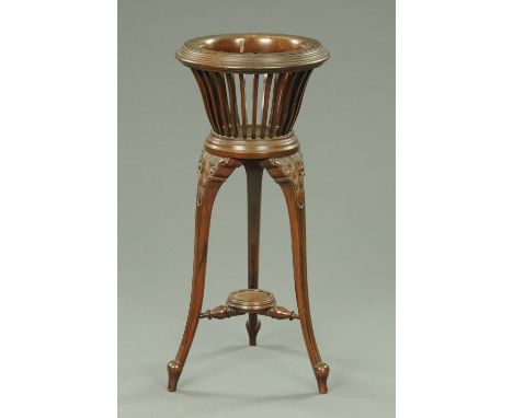 A late Victorian mahogany aspidistra stand, with foliate carved legs united by a centre circular shelf. 