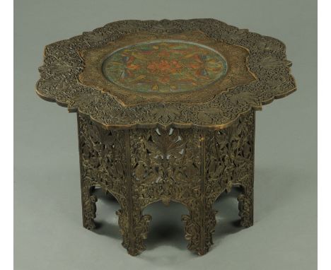 An Indian carved wooden table, with centre brass panel and octagonal base, width 87 cm.