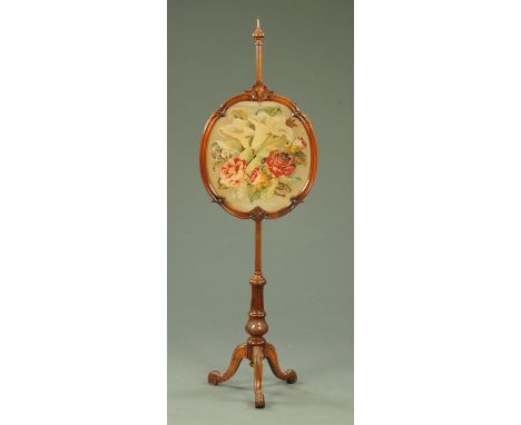 A large Victorian rosewood fire screen, the frame of shaped outline and with woolwork panel and raised on a turned carved and