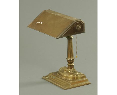 A patinated brass desk lamp, early to mid 20th century, having a fixed shade upon a gun barrel stem terminating in a plume, a