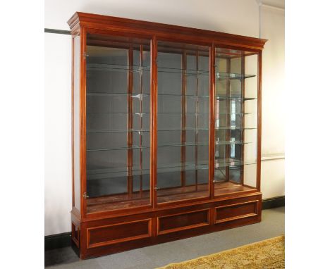 A large Victorian mahogany shop display cabinet, with moulded cornice, three long doors with brass handles and with three pan