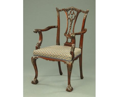 A Chippendale style mahogany armchair, with pierced splat back, outswept arms and stuffover seat upholstered in blue and beig