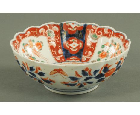 A Japanese Imari bowl, circa 1890, with chrysanthemum, of petal shape, the interior with dragon, framed by shaped panels of b