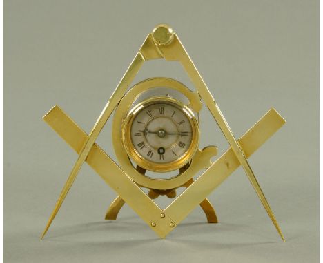 A Masonic brass mounted clock, late 19th century, the silver dial mounted within the letter G, mounted within a compass and s