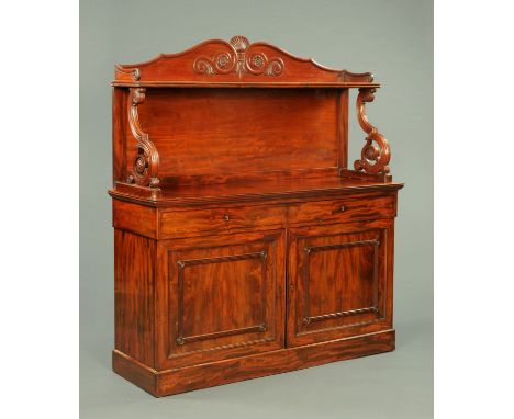 A large William IV mahogany chiffonier, with shell and scroll carved upstand, shelf and further scroll supports, the base fit