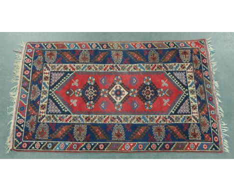 A Turkoman rug, with centre rectangular panel with three repeating diamond and foliate motifs and multiple line border.  Widt