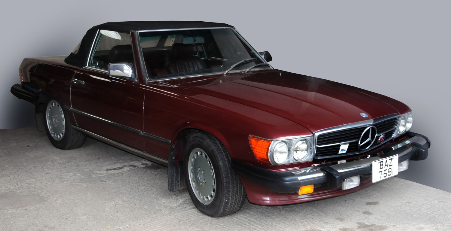 A Mercedes Benz 560SL (Model R107), maroon, soft top two seat sports ...